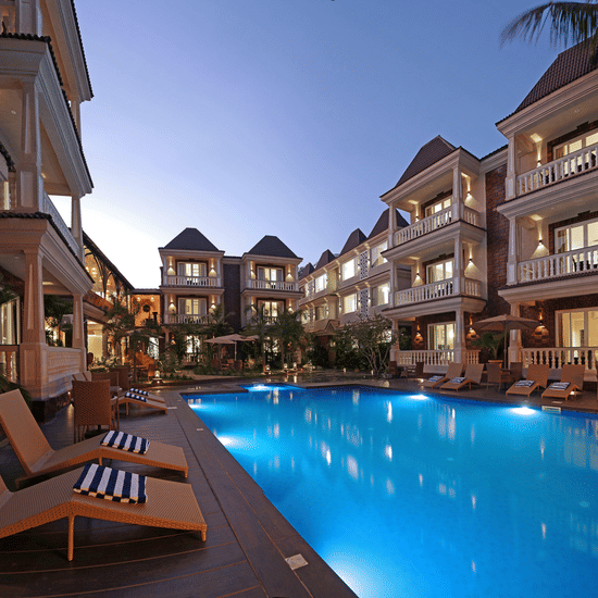 A full view of the Grand Continent, Anjuna - A Sarovar Portico Affiliate Hotel  with buildings and in between swimming pool.